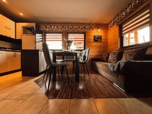 a living room with a table and a couch at Domek Przy Potoku in Murzasichle +25 photos