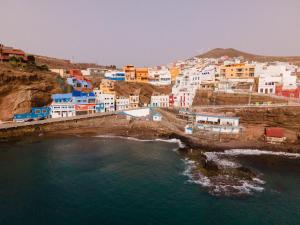 a group of buildings on a hill next to the water at Las Velas in Las Palmas de Gran Canaria