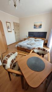 ブワディスワボボにあるPokoje gościnne LAGUNAのベッドルーム1室(ベッド1台、木製テーブル付)