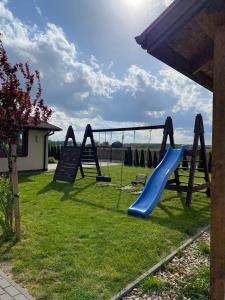a playground with a slide in the grass at Stajnia Bocianie Gniazdo in Uniejow