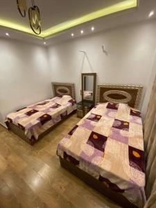 a bedroom with two beds and a mirror at Jordan family in Amman
