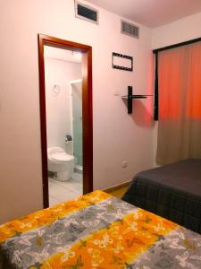 a bedroom with a bed and a bathroom with a toilet at Tucacas, Sotavento in Boca de Aroa
