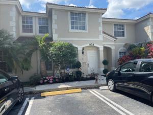 een huis met twee auto's geparkeerd op een parkeerplaats bij Home away from home in West Palm Beach
