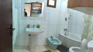 a bathroom with a sink and a toilet and a bath tub at Myni's House in Xai-Xai