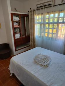 um quarto com uma cama branca e uma janela em Myni's House em Xai-Xai