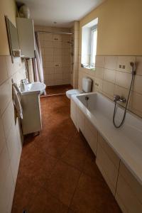 łazienka z wanną, toaletą i umywalką w obiekcie Domek przy Rynku w mieście Głogówek