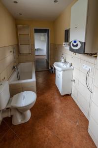 uma casa de banho com um WC, uma banheira e um lavatório. em Domek przy Rynku em Głogówek