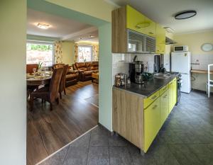a kitchen with yellow cabinets and a dining room at Domek przy Rynku in Głogówek