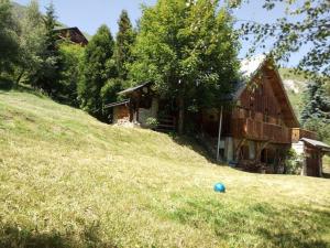 una casa en una colina con una bola azul en el césped en Chalet Savoyard vue panoramique, en Jarrier