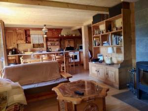 a living room with a couch and a table at Chalet Savoyard vue panoramique in Jarrier