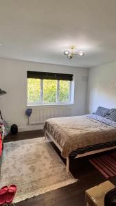 a bedroom with a large bed and a window at Luxury Home with Gym/Outdoor play area - 40 mins from Luton/Stansted in Knebworth