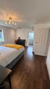 a bedroom with a large bed and a wooden floor at Luxury Home with Gym/Outdoor play area - 40 mins from Luton/Stansted in Knebworth