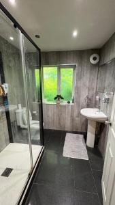 a bathroom with a shower and a sink and a toilet at Luxury Home with Gym/Outdoor play area - 40 mins from Luton/Stansted in Knebworth