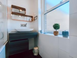 a bathroom with a sink and a window at Charming Two Bedroom Apartment In Strawberry Hill in Twickenham