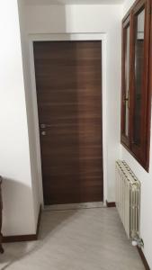 eine braune Tür in einem weißen Zimmer mit Fenster in der Unterkunft Venezia in Suite - Luxury Accommodation in Venedig