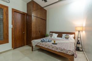 - une chambre avec un lit et une tête de lit en bois dans l'établissement Dhruva - Lux 3BHK in Dun, à Dehradun