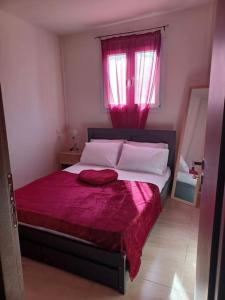 una camera da letto con un grande letto con una coperta rossa di Robin Hood ad Akrotiri
