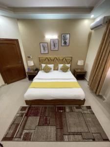 a bedroom with a large bed and two night stands at Safari Hotel in Islamabad