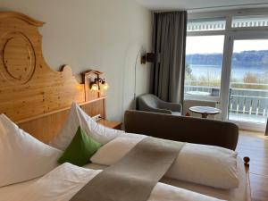 a hotel room with a bed and a large window at Hotel Landhaus Sternen in Sipplingen