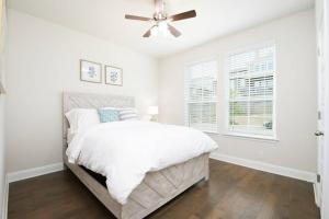a white bedroom with a bed and a ceiling fan at Texas Luxury Home 3 in San Antonio