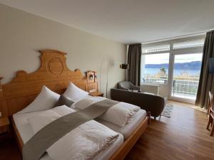 a bedroom with a large bed and a large window at Hotel Landhaus Sternen in Sipplingen