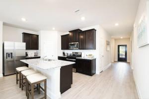 a kitchen with black cabinets and a counter top at Texas Luxury Home 3 in San Antonio