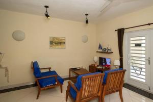 クラレンダイクにあるTrupial G3 Relax & Dive Resort Bonaire Villageのリビングルーム(青い椅子2脚、デスク付)