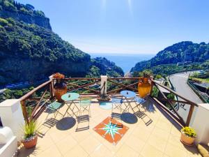 a balcony with tables and chairs and a view of the mountains at VillaNina in Pontone