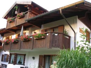 a building with wooden balconies with flowers on it at Ferienwohnung Claudia in Oberammergau