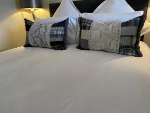 a bed with several pillows on top of it at Luxury 5 Star House - Ard Craig House Ballachulish Glencoe in Glencoe