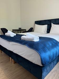 2 camas con mantas azules y blancas encima de ellas en IRIS Aparthotel, en Cracovia