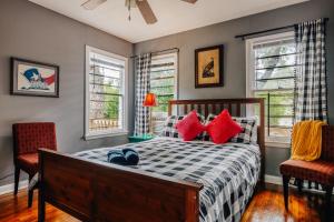 a bedroom with a bed and two chairs and windows at 2025 Award-Winning Treehouse Game Days, Steps to UT Stadium in Austin