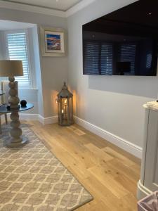 ein Wohnzimmer mit einem Tisch und einer Lampe in der Unterkunft Brand New! Bagpipers Luxury Hideaway at Ard Craig House Glencoe in Glencoe