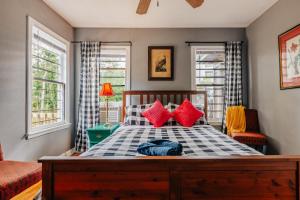 1 dormitorio con 1 cama grande con almohadas rojas en 2BR 3BDs Historical TREE HOUSE on UT Campus, en Austin