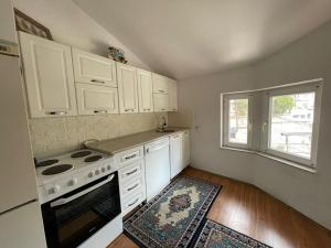 a kitchen with white cabinets and a stove at Deni house in Prizren