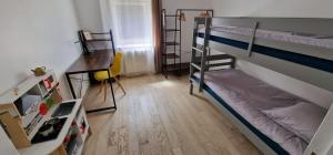 Zimmer mit 2 Etagenbetten und einem Schreibtisch in der Unterkunft Bel appartement rénové avec de beaux volumes in Flavigny-sur-Moselle
