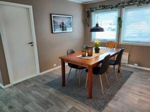 a dining room with a wooden table and chairs at Sentrumsnær overnatting in Alta