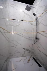 een witte marmeren badkamer met een douchecabine bij Next Hotel Samarkand in Samarkand