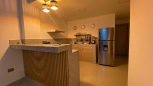 a kitchen with a stainless steel refrigerator and a counter at Bellavista Loft Jacuzzi & Balcón in Guayaquil