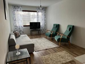 Una sala de estar con un sofá y sillas y un televisor. en Apartment Tehtaankatu, en Kokkola