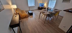 ein Wohnzimmer mit einem Esstisch und Stühlen in der Unterkunft Bel appartement rénové avec de beaux volumes in Flavigny-sur-Moselle