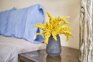 a black vase with yellow flowers on a table at Seaside Serenity: Charming 2BR Escape - Parking in Scarborough