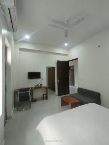 a bedroom with a bed and a desk and a tv at Executive House in Lucknow