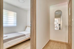 a small bedroom with a bed and a mirror at Apartments Pavic in Risan