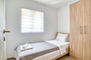 リサンにあるApartments Pavicのベッドと窓のある白い寝室 +28枚の写真