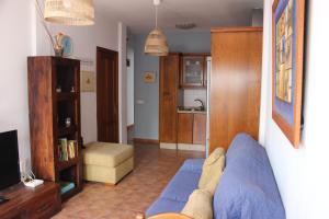 een woonkamer met een blauwe bank en een keuken bij Casa Noah Famara in Famara