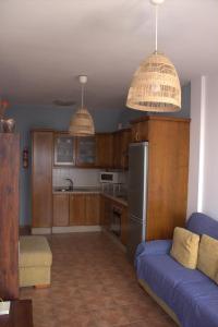 een woonkamer met een blauwe bank en een keuken bij Casa Noah Famara in Famara