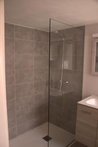 een douche met een glazen deur in de badkamer bij Casa Noah Famara in Famara