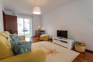 a living room with a couch and a tv at Mónaco Nest in Ponta Delgada