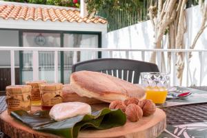 uma sandes numa mesa com nozes e sumo de laranja em Mónaco Nest em Ponta Delgada